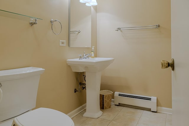 bathroom with a baseboard heating unit, toilet, tile patterned floors, and baseboards
