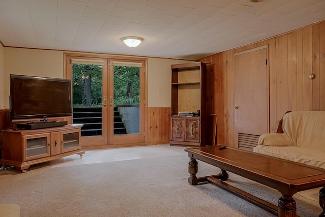 carpeted living area with wood walls and wainscoting
