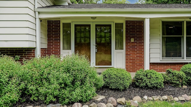 property entrance with brick siding and a porch