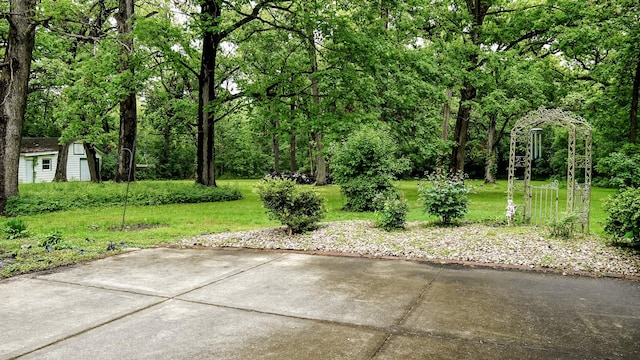 view of green lawn featuring an outdoor structure