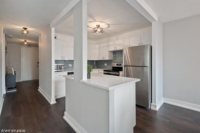 405 N Wabash Ave Unit 713, Chicago, IL 60611 - kitchen with stainless steel appliances, dark wood finished floors, backsplash, light countertops, and white cabinetry