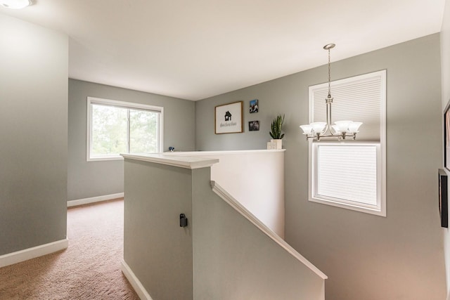 86 E Hummingbird Ave, Cortland, IL 60112 - hallway with an upstairs landing, baseboards, light carpet, and a chandelier