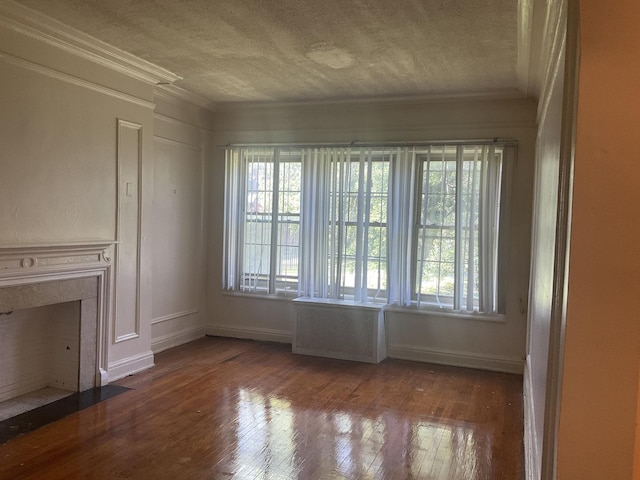 6832 S S Shore Dr Unit 1, Chicago, IL 60649 - unfurnished living room featuring plenty of natural light, a textured ceiling, wood finished floors, and crown molding