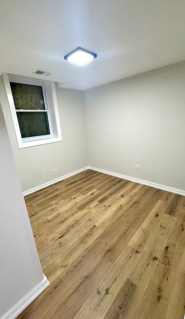 1110 W Marquette Rd, Chicago, IL 60621 - empty room with wood finished floors and baseboards