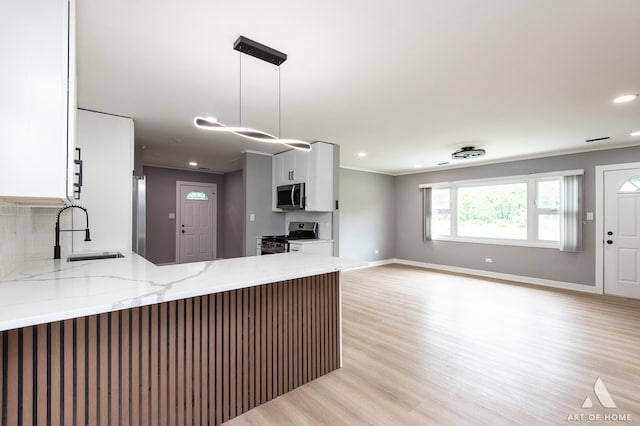 16568 Plainview Dr, Markham, IL 60428 - kitchen with appliances with stainless steel finishes, a sink, light stone countertops, a peninsula, and white cabinets