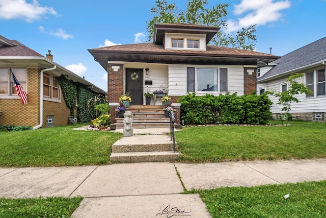 905 Kelly Ave, Joliet, IL 60435 - bungalow-style house with a front lawn, covered porch, and brick siding