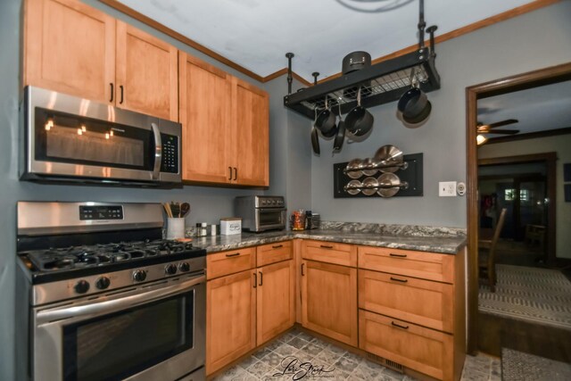 905 Kelly Ave, Joliet, IL 60435 - kitchen with appliances with stainless steel finishes, ceiling fan, dark stone counters, brown cabinets, and ornamental molding