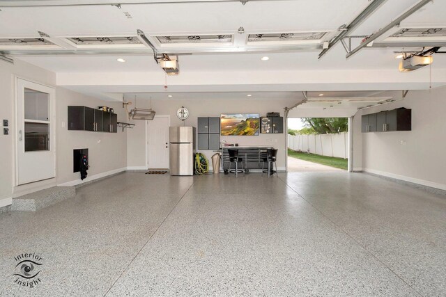 883 White Tail Bnd, Manteno, IL 60950 - garage featuring freestanding refrigerator, a garage door opener, and baseboards