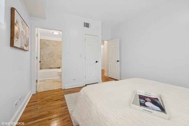 3849 W Ainslie St Unit 1, Chicago, IL 60625 - bedroom with light wood-style floors, baseboards, and ensuite bathroom