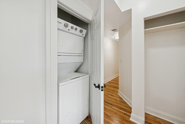 3849 W Ainslie St Unit 1, Chicago, IL 60625 - washroom featuring stacked washer and clothes dryer, wood finished floors, and baseboards