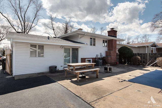 3034 190th St, Lansing, IL 60438 - back of house featuring a patio, a chimney, central AC, a shingled roof, and brick siding