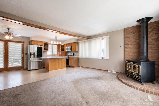 3034 190th St, Lansing, IL 60438 - kitchen featuring stainless steel appliances, open floor plan, brown cabinets, a wood stove, and a kitchen island