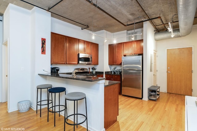 520 S State St Unit 614, Chicago, IL 60605 - kitchen featuring stainless steel appliances, light wood-style flooring, a peninsula, and a kitchen bar