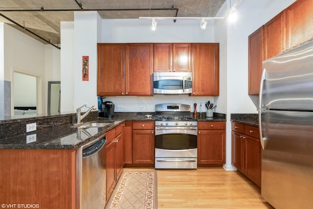 520 S State St Unit 614, Chicago, IL 60605 - kitchen featuring stainless steel appliances, a sink, rail lighting, light wood-style flooring, and dark stone counters
