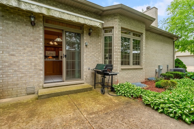 11104 Karen Dr, Orland Park, IL 60467 - doorway to property featuring a chimney, brick siding, and central air condition unit