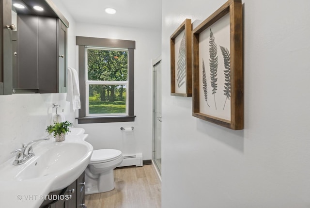 2309 N Riverside Dr, Mchenry, IL 60051 - full bath with a baseboard heating unit, a shower stall, wood finished floors, and vanity