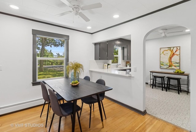 2309 N Riverside Dr, Mchenry, IL 60051 - dining room featuring ceiling fan, a baseboard radiator, a baseboard heating unit, arched walkways, and healthy amount of natural light