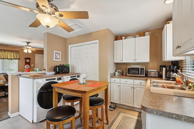 129 S Hammes Ave, Joliet, IL 60436 - kitchen with stainless steel microwave, a sink, a ceiling fan, light tile patterned floors, and washer / clothes dryer