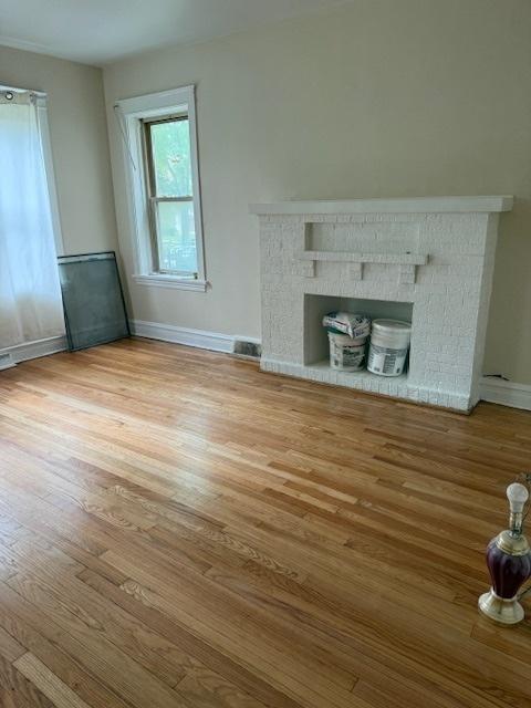 1723 N Monitor Ave, Chicago, IL 60639 - unfurnished living room featuring wood finished floors and a brick fireplace
