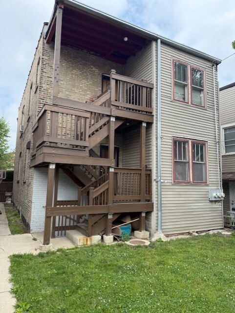 1723 N Monitor Ave, Chicago, IL 60639 - rear view of property featuring a lawn, brick siding, stairway, and a wooden deck