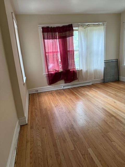 1723 N Monitor Ave, Chicago, IL 60639 - empty room with wood finished floors and baseboard heating