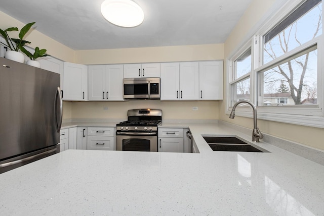 8048 W Magnolia Dr, Frankfort, IL 60423 - kitchen featuring appliances with stainless steel finishes, a sink, light stone counters, and white cabinets