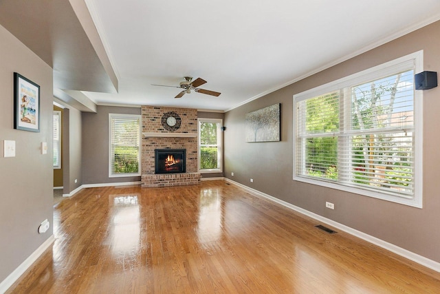 325 Indian Ridge Trl, Wauconda, IL 60084 - unfurnished living room with baseboards, a ceiling fan, light wood-type flooring, ornamental molding, and a brick fireplace