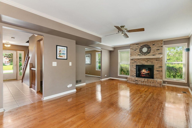 325 Indian Ridge Trl, Wauconda, IL 60084 - unfurnished living room with baseboards, light wood-style flooring, a ceiling fan, crown molding, and a fireplace