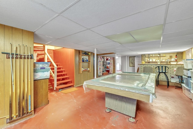 5434 W School St, Chicago, IL 60641 - playroom with concrete flooring, billiards, a paneled ceiling, a fireplace, and wood walls