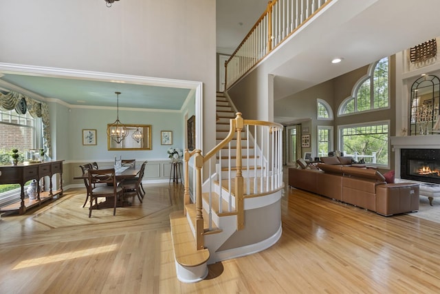 20142 N Deer Chase Ct, Deer Park, IL 60010 - stairway featuring a towering ceiling, plenty of natural light, a glass covered fireplace, wood finished floors, and ornamental molding