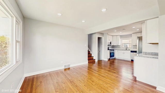 524 Escanaba Ave, Calumet City, IL 60409 - unfurnished living room with light wood finished floors, recessed lighting, stairs, a sink, and baseboards