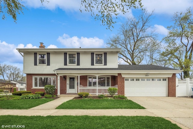 265 W Adams St, Elmhurst, IL 60126 - traditional-style house with brick siding, an attached garage, concrete driveway, a chimney, and covered porch