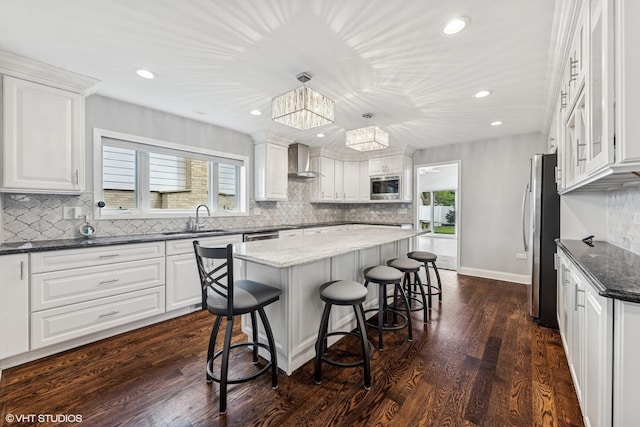 265 W Adams St, Elmhurst, IL 60126 - kitchen featuring appliances with stainless steel finishes, a sink, wall chimney exhaust hood, a kitchen breakfast bar, and a center island