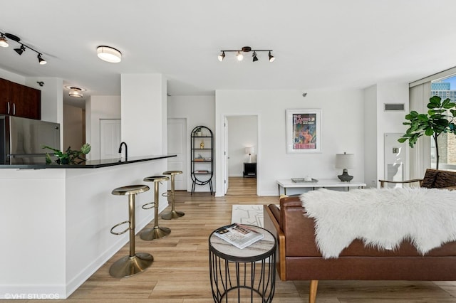 757 N Orleans St Unit 711, Chicago, IL 60654 - living room with rail lighting, light wood-style flooring, and baseboards