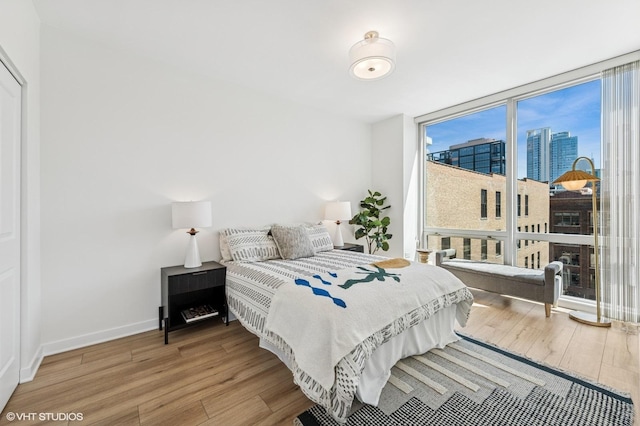 757 N Orleans St Unit 711, Chicago, IL 60654 - bedroom with wood finished floors, expansive windows, baseboards, and a city view