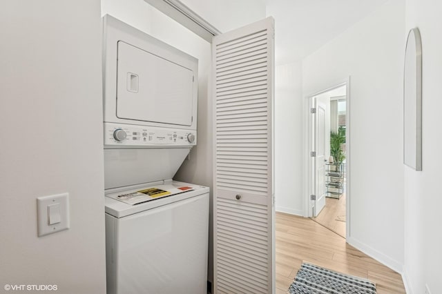 757 N Orleans St Unit 711, Chicago, IL 60654 - laundry room featuring stacked washer and clothes dryer, light wood-type flooring, and baseboards