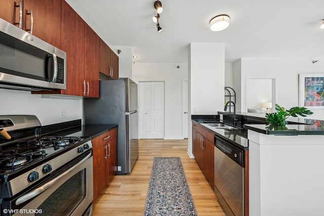 757 N Orleans St Unit 711, Chicago, IL 60654 - kitchen with stainless steel appliances, dark countertops, a sink, and light wood-type flooring