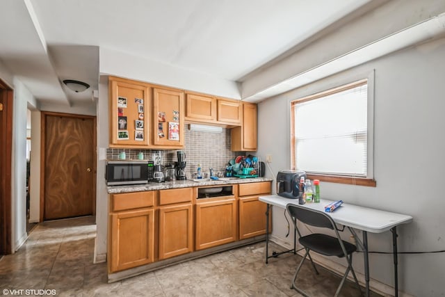 32 E 137th St, Riverdale, IL 60827 - kitchen with stainless steel microwave, tasteful backsplash, brown cabinetry, and light stone counters