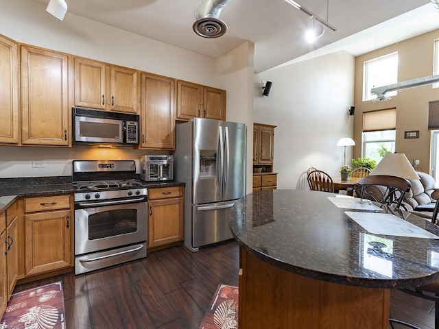 1716 Simms St Unit 0, Aurora, IL 60504 - kitchen with stainless steel appliances, track lighting, dark wood-type flooring, a kitchen island, and dark stone counters
