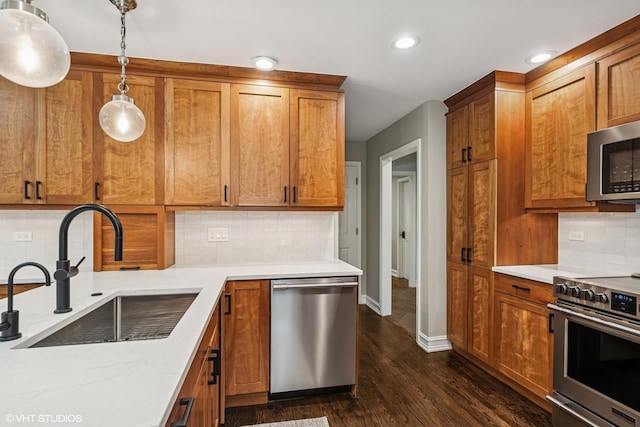 506 Westgate Rd, Deerfield, IL 60015 - kitchen featuring stainless steel appliances, a sink, brown cabinets, dark wood finished floors, and baseboards