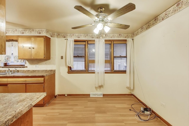 6636 S Rockwell St, Chicago, IL 60629 - kitchen featuring light wood-type flooring, light countertops, baseboards, and ceiling fan