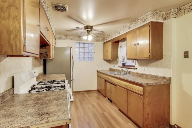 6636 S Rockwell St, Chicago, IL 60629 - kitchen featuring a sink, a ceiling fan, light wood-type flooring, tasteful backsplash, and light countertops