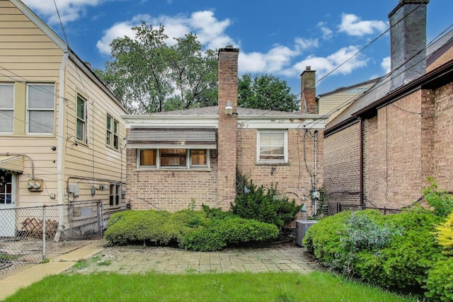 6636 S Rockwell St, Chicago, IL 60629 - view of home's exterior featuring a chimney, brick siding, and cooling unit