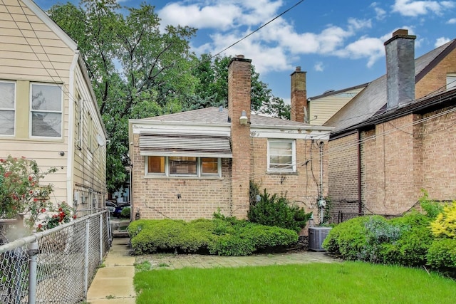 6636 S Rockwell St, Chicago, IL 60629 - back of house with brick siding, a chimney, and cooling unit