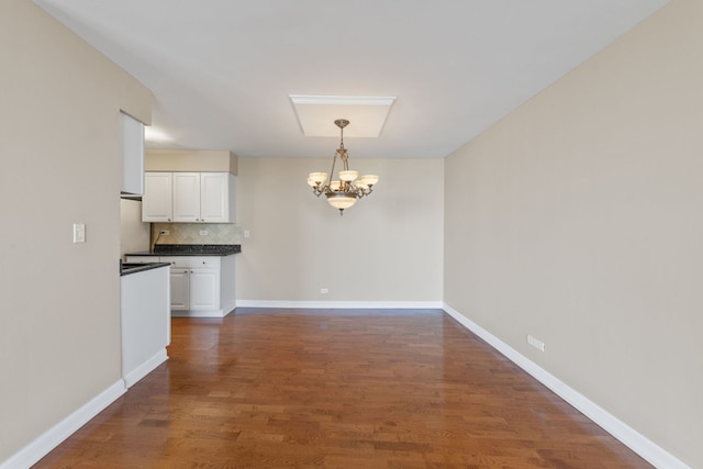 40 N Tower Rd Unit 14B, Oak Brook, IL 60523 - unfurnished dining area with a chandelier, dark wood-type flooring, and baseboards