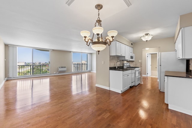 40 N Tower Rd Unit 14B, Oak Brook, IL 60523 - kitchen featuring white appliances, dark countertops, open floor plan, a sink, and a chandelier