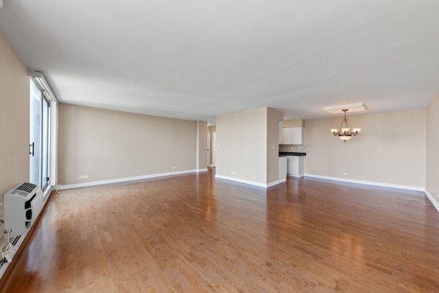 40 N Tower Rd Unit 14B, Oak Brook, IL 60523 - unfurnished living room featuring a chandelier, light wood-style flooring, and baseboards