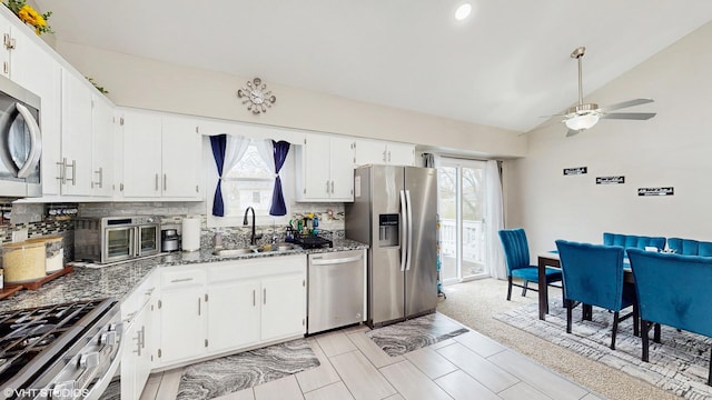 2080 Maplewood Cir, Naperville, IL 60563 - kitchen featuring stainless steel appliances, a sink, dark stone countertops, lofted ceiling, and decorative backsplash