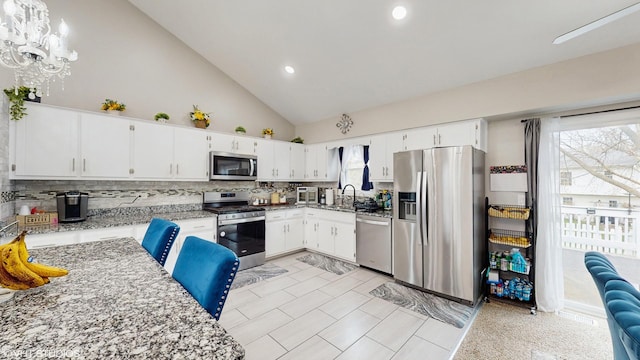 2080 Maplewood Cir, Naperville, IL 60563 - kitchen with stainless steel appliances, backsplash, a sink, light stone countertops, and high vaulted ceiling