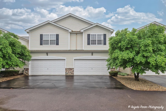 2704 Kendall Xing Unit 2704, Johnsburg, IL 60051 - view of front of property with asphalt driveway, a garage, and stone siding